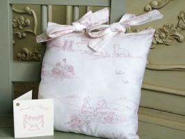 A very delicate coloured cotton toile with scenes of young children having a country picnic.  Measuring 10" x 10" and finished with a thick baby pink fabric to the rear and two bow ties to the top. Price: &pound;13.54