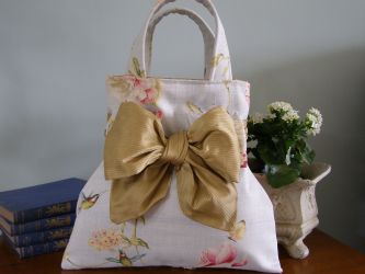 Our French & Floral "Raphi" handbag is so sweet and is most definately one of my favourites!  The raphi handbag has a French inner lining, a beautiful mustard silk co-ordinating lining and an inside "Raphi" fabric pocket with our own French & Floral label. Finished with a large mustard silk bow this handbag is perfect. Our "Raphi" hand bag stands on its own - you will not be disappointed! 
 Price: &pound;36.43