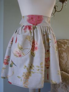 Our "Raphi" French apron is sumptuous.
Made with generous amounts of gather and a deep, high waistband.  Every "Raphi" apron has been made with a large front pocket and a long wide tie to the rear.

Finished with fine scalloped edge contrasting stitching.
(Raphi daughters co-ordinating pinafore dress available). Fully Machine Washable. Price: &pound;37.60