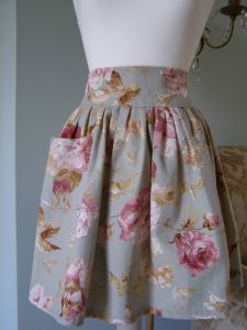 Our Vintage Rose French apron is sumptuous. Made with generous amounts of gather and a deep, high waistband. Every Vintage Rose apron has been made with a large front pocket and a long wide tie to the rear. Finished with fine scalloped edge contrasting stitching. (Vintage Rose girls co-ordinating pinafore dress available). Fully Machine Washable.
 Price: &pound;37.60